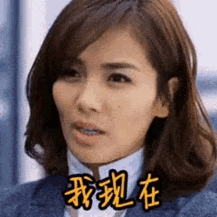 a woman in a suit is making a funny face with chinese writing on her face .
