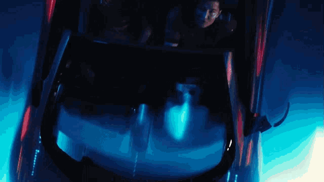 a man is riding a roller coaster in a dark room