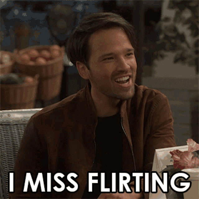 a man is sitting at a table with a sign that says i miss flirting on it