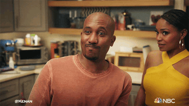 a man and a woman are standing in a kitchen with the nbc logo on the bottom right