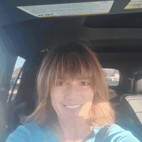 a woman sits in a car with a warning label on the sunroof