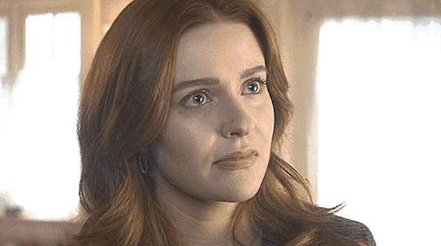 a close up of a woman 's face with a serious look on her face