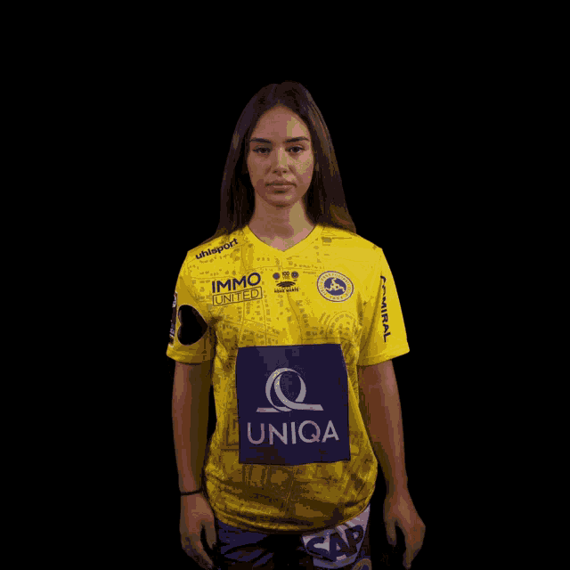 a woman wearing a yellow shirt that says uniqa