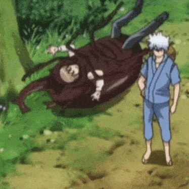 a man is standing next to a large beetle that is laying on its back .