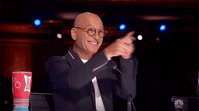 a man applauds in front of a cup that says sonic