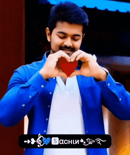 a man in a blue shirt making a heart with his hands