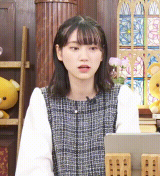 a young woman is sitting at a table with a tablet in front of her .