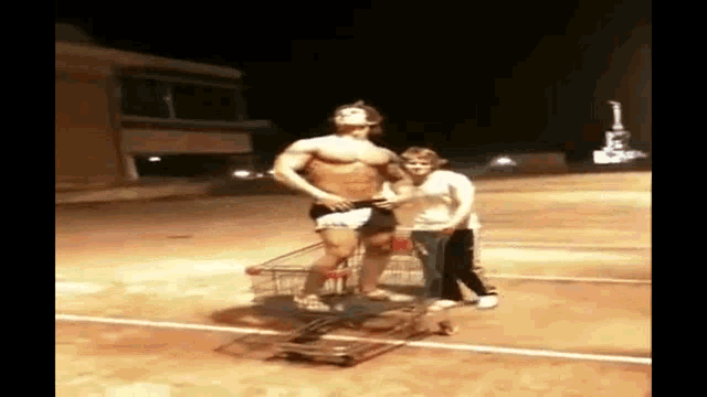 a man without a shirt is pushing a shopping cart with a woman in it