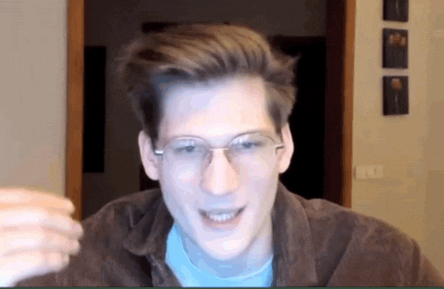 a young man wearing glasses and a brown jacket is smiling and looking at the camera .