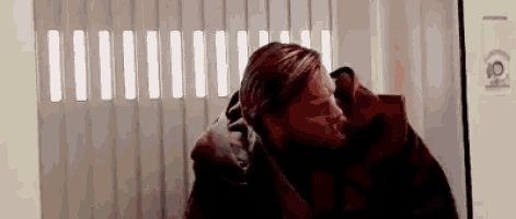 a man is wrapped in a blanket while standing in front of a door .