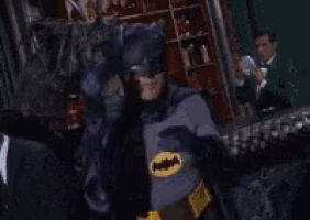a man in a batman costume covering his eyes