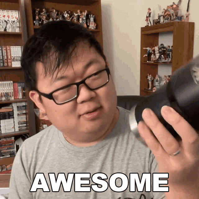a man wearing glasses and a grey shirt with the word awesome on the front