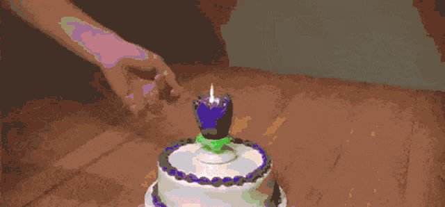 a birthday cake with purple frosting and a purple candle
