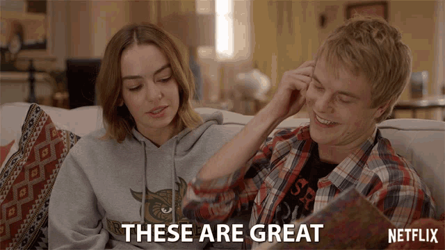 a man and a woman are sitting on a couch with the words " these are great " in the corner