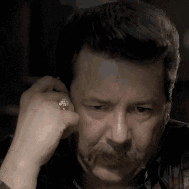 a man with a ring on his finger is looking down