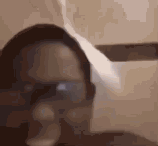a close up of a person 's face with glasses and a blurred background .