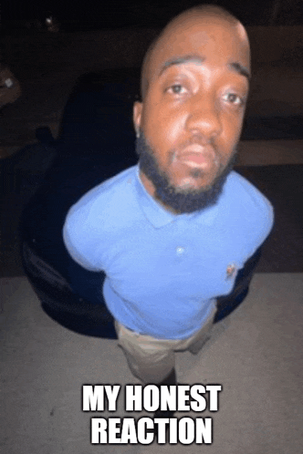 a man in a blue shirt is standing in front of a car with the words " my honest reaction " written below him