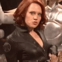 a woman in a black suit is standing next to a mannequin .