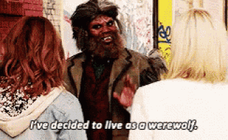 a man dressed as a werewolf talking to two women .
