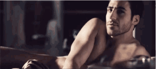 a man without a shirt is laying in a bathtub .