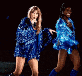 a woman in a blue sequined dress is dancing
