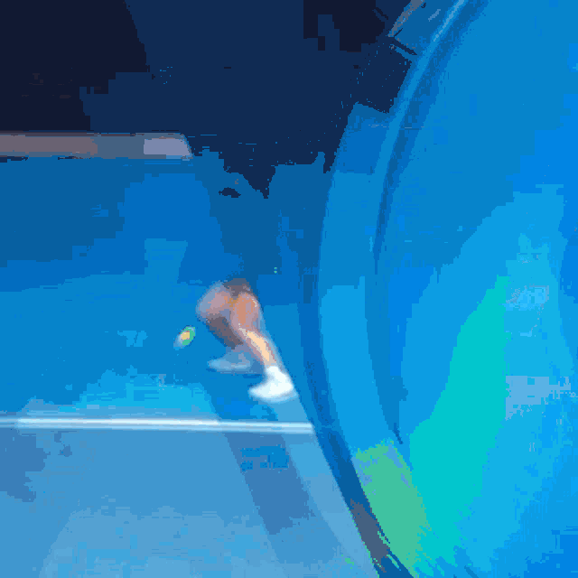 a woman in a yellow shirt is swinging a tennis racquet on a blue court