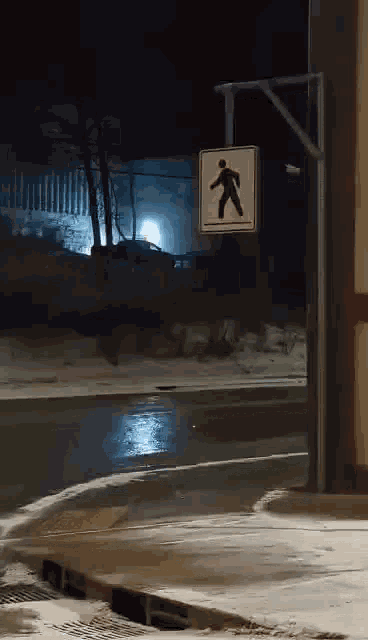 a pedestrian crossing sign is hanging on a pole