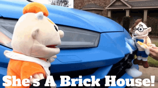 two stuffed animals standing in front of a blue car with the words she 's a brick house