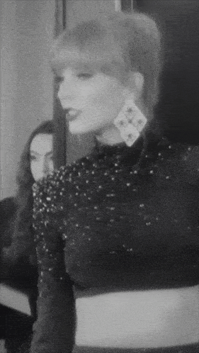 a black and white photo of a woman wearing a black dress