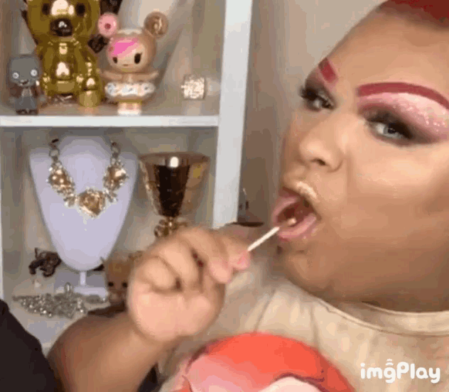 a woman is eating a lollipop in front of a shelf full of jewelry ..