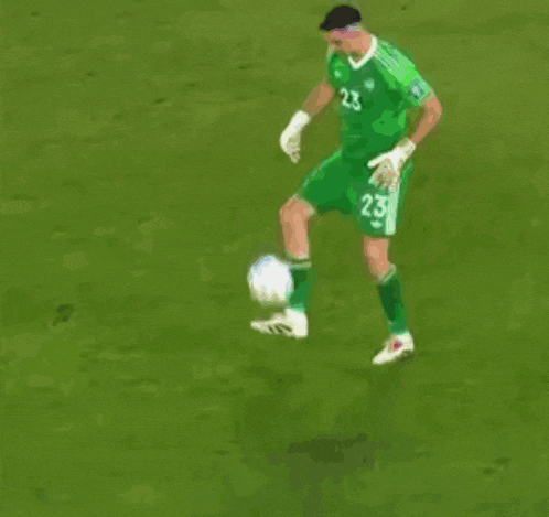 a soccer player with the number 23 on his jersey is kicking a ball