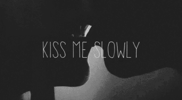 a black and white photo of a man and woman kissing with the words kiss me slowly in the background