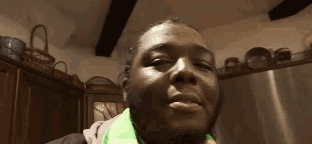 a man with a scarf around his neck is making a funny face .