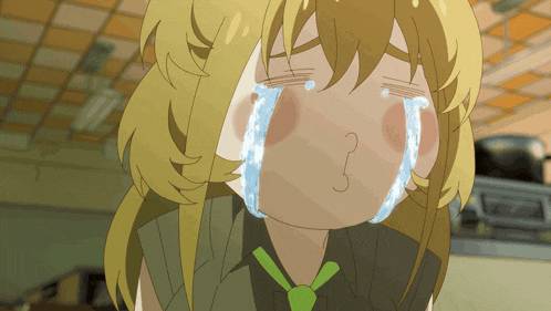 a girl with blonde hair and a green tie is crying