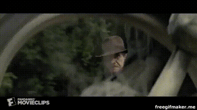 a man in a hat is looking out of a window in a movie clip