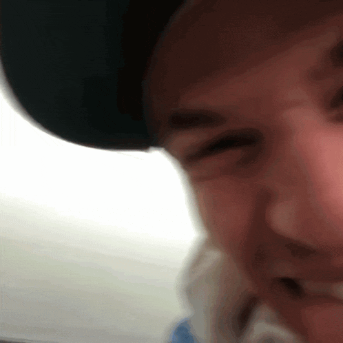 a close up of a person wearing a hat and smiling