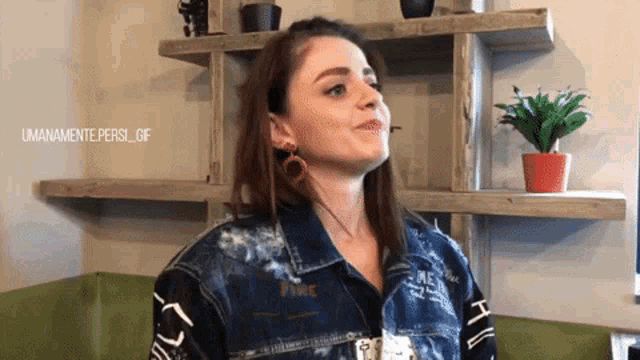 a woman wearing a denim jacket with the word fire on the front