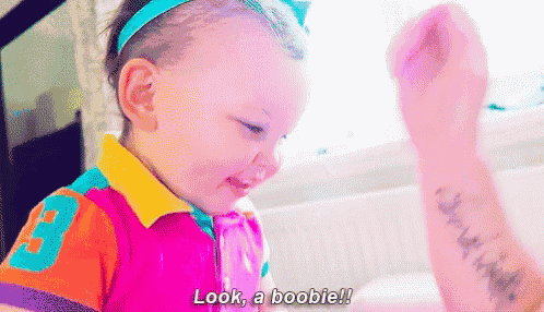 a little girl with a tattoo on her arm says look a boobie