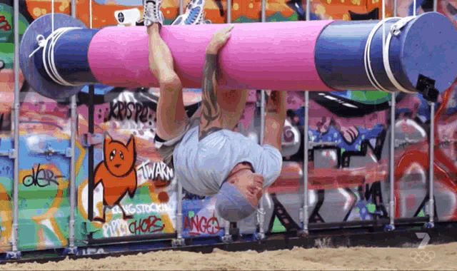 a man is doing a handstand in front of a wall that has graffiti on it including one that says angels