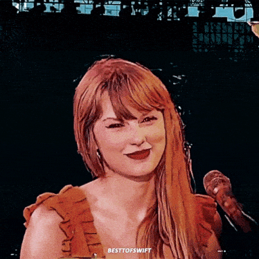 a woman with red hair stands in front of a microphone with the words besttofswift written on the bottom