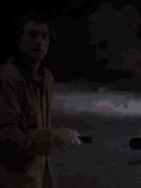 a man is holding a flashlight in the dark
