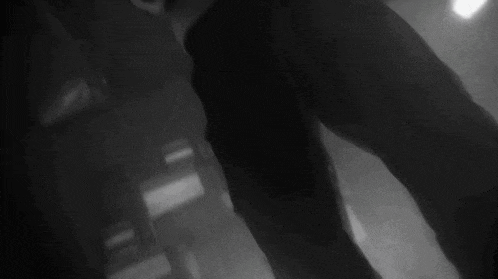 a black and white photo of a person covering their face with their hands .
