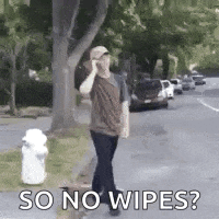 a man is walking down a street talking on a cell phone .