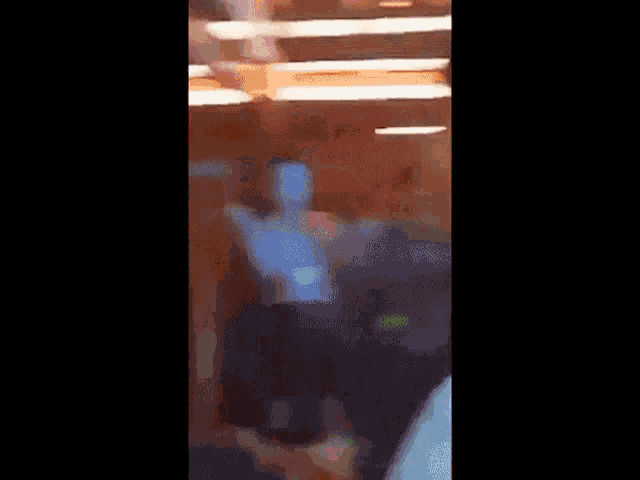 a blurry picture of a group of people standing in a room with their arms in the air .