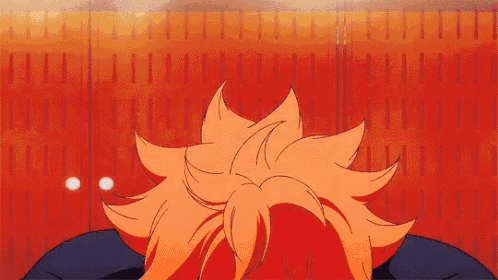 a close up of a person 's head in front of a red wall .