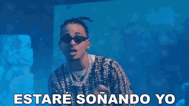 a man wearing sunglasses and a sweater with the words estare sonando yo on it