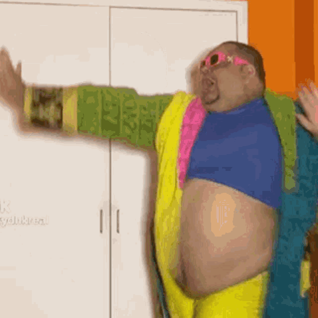 a fat man in a colorful costume is standing in front of a closet with his arms outstretched .