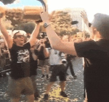 a man in a black shirt is holding a trophy in his hand