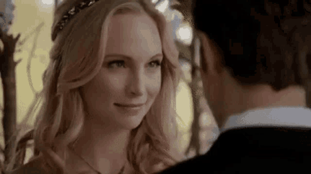 a man and a woman are looking at each other and smiling .