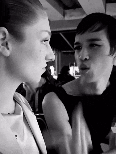 a black and white photo of a man and woman looking at each other
